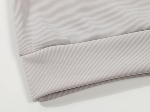 Close-up of light grey ribbed knit texture on men's polo sweatshirt cuff and hemline