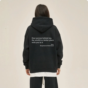 Detailed back view of oversized black hoodie with white inspirational quote print