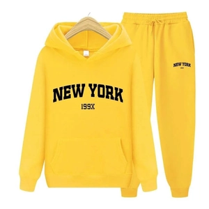 Détail du survêtement jaune New York avec lettrage noir et finitions aux poignets côtelés