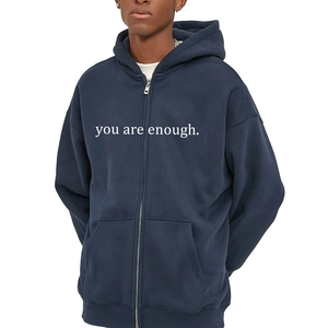 Detail of navy blue oversized hoodie featuring white 'you are enough' slogan print
