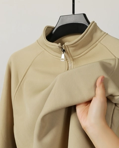 Detail of premium ribbed fabric elasticity on beige half-zip polo sweatshirt for men
