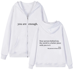 Detail view of white zip-up hoodie featuring motivational back text and kangaroo pockets