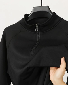 Detailed macro view of black quarter-zip polo shirt with fine ribbed knit fabric texture