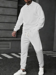 Detailed view of the woven V-shaped texture on a white long-sleeve polo shirt and trousers