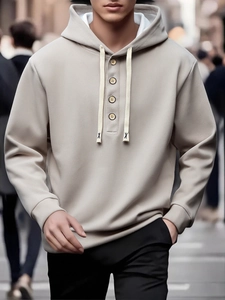 Detail of khaki men hoodie featuring a buttoned henley neckline and drawstring with X accent