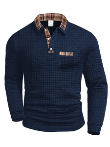 Detail of waffle knit fabric and plaid patchwork pocket on navy blue long sleeve polo shirt
