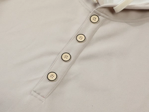 Detail of light beige hoodie showing four-button placket with engraved Classic buttons