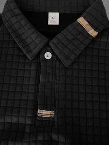 Detail of waffle texture men's polo shirt featuring a plaid collar lining and buttons