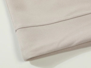 Macro shot of double-needle stitching on light gray hoodie cuffs and knit cotton fabric