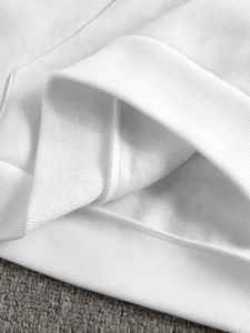 Detail of white hoodie showing premium ribbed cuffs and soft fleece lining texture