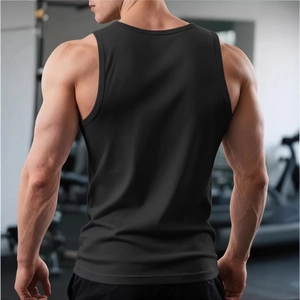 Back view of men's black athletic tank top showing muscle definition in a gym setting