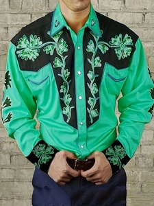 Detail of green western shirt featuring black contrast panels and floral embroidery motifs