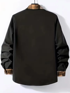 Detail of men's black shirt showing plaid patterned collar and cuffs in macro view