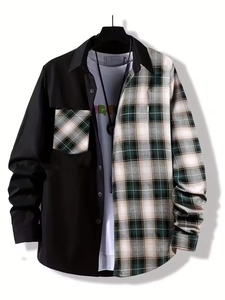 Detail view of men's long sleeve shirt featuring black solid and plaid patchwork design