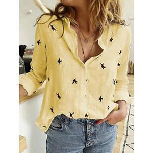 Detalle de camisa de lino amarilla para mujer con estampado de aves y botones blancos