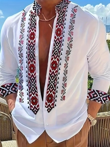 Dettaglio del ricamo etnico geometrico su camicia bianca a maniche lunghe con colletto