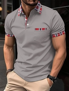 Detailed view of dark grey men's polo shirt with red and blue tartan plaid collar and pocket