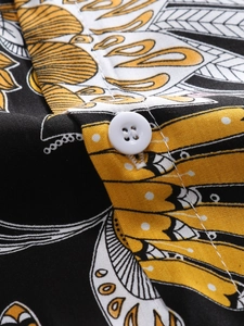 Macro shot of tropical print shirt showing white button and detailed fabric texture