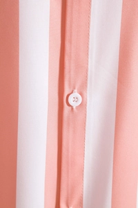 Close-up of white buttons and pink striped fabric texture on men's casual shirt