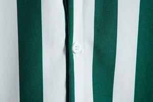 Close-up of green and white vertical striped shirt showing fabric texture and white button