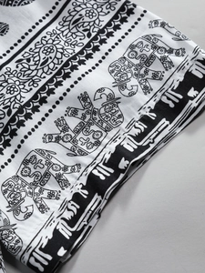 Detailed close-up of ethnic elephant and paisley patterns on a black and white cotton shirt
