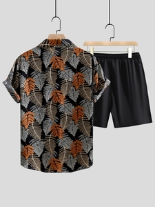 Detail of men's short sleeve shirt with fern leaf print and black casual shorts