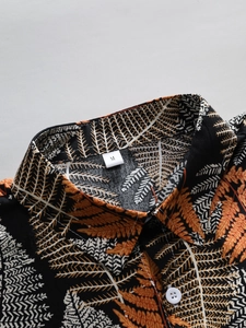 Detail of tropical leaf print shirt collar with standard lapel and size M tag