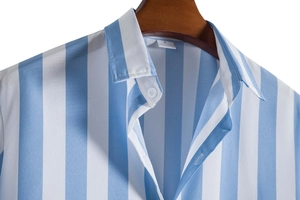 Detail of blue and white vertical striped men shirt collar and resin buttons on hanger