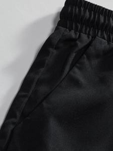 Detailed shot of men's black knit shorts with elastic waistband and side pockets