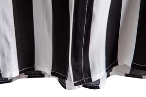 Detail of white and black vertical striped shirt showing precise stitching and fabric texture