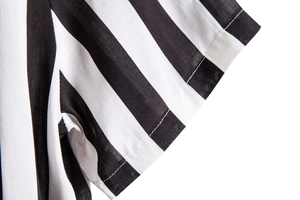 Detailed close-up of the black and white vertical striped fabric and sleeve stitching