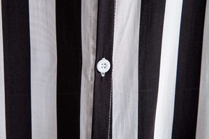 Macro detail of vertical black and white striped shirt with button placket craftsmanship