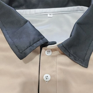 Close-up of polo shirt collar with white buttons and visible M size label detail