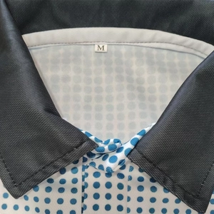 Macro shot of men's polo collar with blue dots, black lining, and size M label