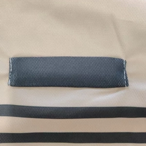 Macro detail of breathable honeycomb mesh fabric with grey stripes and durable stitching