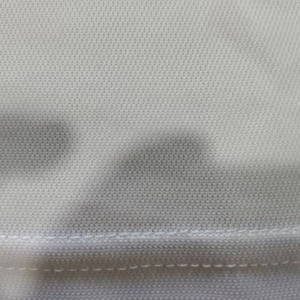 Detailed macro shot of white breathable honeycomb mesh fabric and flatlock stitching on polo shirt