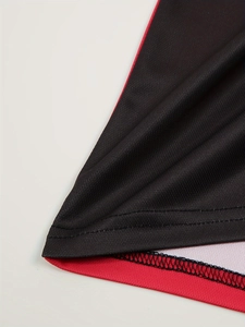 Détail du tissu en maille respirante rouge et noir avec coutures à double aiguille