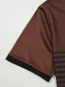 Détail macro du polo en mesh à rayures marron avec bord-côte noir sur la manche courte