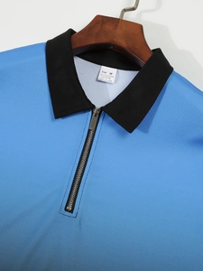 Close-up of blue polo shirt with black contrast collar, silver zipper and fabric texture