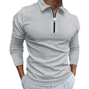 Detail of light grey waffle knit fabric texture on men's long sleeve zip polo shirt