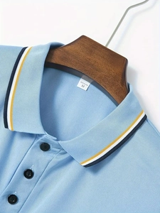 Detailed close-up of light blue polo collar with contrast stripes and textured cotton fabric