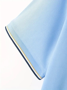 Detail of light blue polo shirt cuff featuring tricolor striped ribbed knit texture