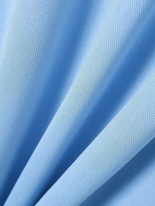 Close-up of light blue knitted polo shirt fabric showing breathable mesh texture details