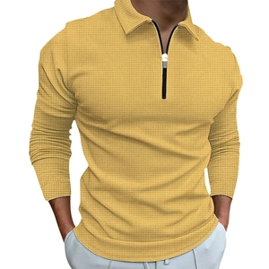 Detail of waffle knit fabric and half-zip collar on men's mustard yellow long sleeve polo