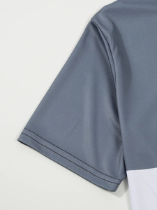 Détail de la manche d'un polo gris et blanc en maille avec ourlet renforcé à double couture