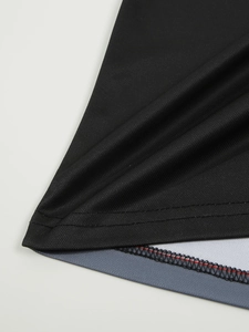 Détail de la double couture renforcée et du tissu en maille respirante sur le polo noir