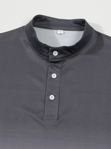 Détail de l'encolure d'un polo gris foncé avec col montant et trois boutons blancs