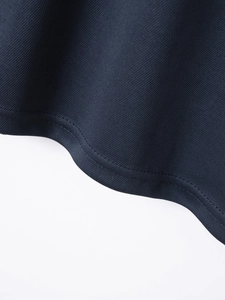 Close-up of navy blue polo shirt hem featuring breathable mesh texture and flat stitching