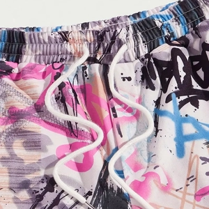 Close-up of men's casual shorts with colorful graffiti print and drawstring waistband