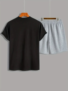 Dettaglio di una maglietta nera a girocollo e pantaloncini sportivi grigi in maglia con elastico